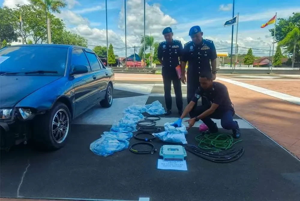 Baderulhisham (tengah) melihat gulung kabel tersebut yang dibakar sebelum dijual kepada pemilik premis barang lusuh.