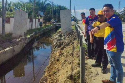 Suee Lim (kanan) meninjau kerja-kerja menaik taraf saliran longkang di persimpangan U Jalan FR5 berhampiran SK Sungai Leman, pada Ahad.