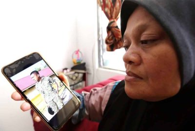 Junaedah menatap gambar kenangan anaknya, Muhammad Irfan Haiqal ketika ditemui di kediamannya pada Ahad.