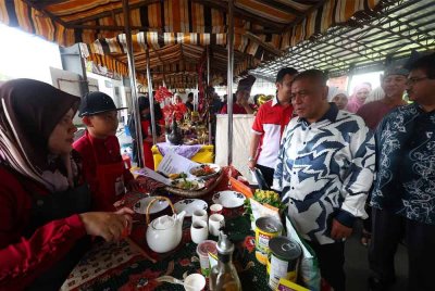 Saarani (dua dari kanan) meninjau ruang pameran yang disediakan sempena Warisan@Pasir Salak 2025 di Kompleks Pasar Tani Kekal, Kampung Gajah pada Ahad.