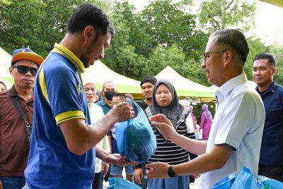Fahmi menyampaikan bantuan Madani di Laman Komuniti Madani di Dataran Kuala Haji Ibrahim, Kampung Sungai Acheh pada Program Bakti@Komuniti Madani di sini hari ini. - Foto: Bernama
