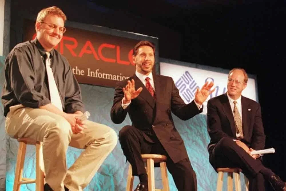 Ellison (tengah) duduk di antara Marc Andreessen (kiri) dan Jan-Pieter Scheerder dalam foto tahun 1996.