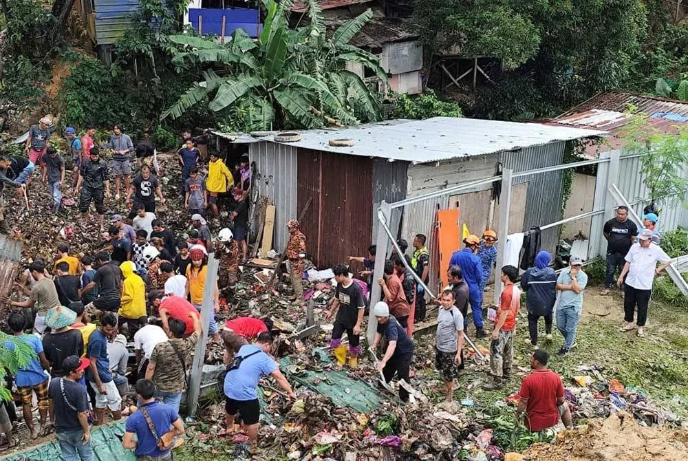 Seorang maut tertimbus manakala empat lagi sempat menyelamatkan diri daripada runtuhan tanah yang menghempap sebuah rumah di Kampung Cenderakasih di sini pada Isnin. Foto JBPM Sabah