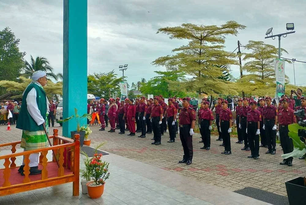Abdul Hadi memeriksa perbarisan Unit Amal sebelum menyampaikan ucapan dasar pada Muktamar Pas di Kompleks Pas Kedah, Kota Sarang Semut pada Isnin.