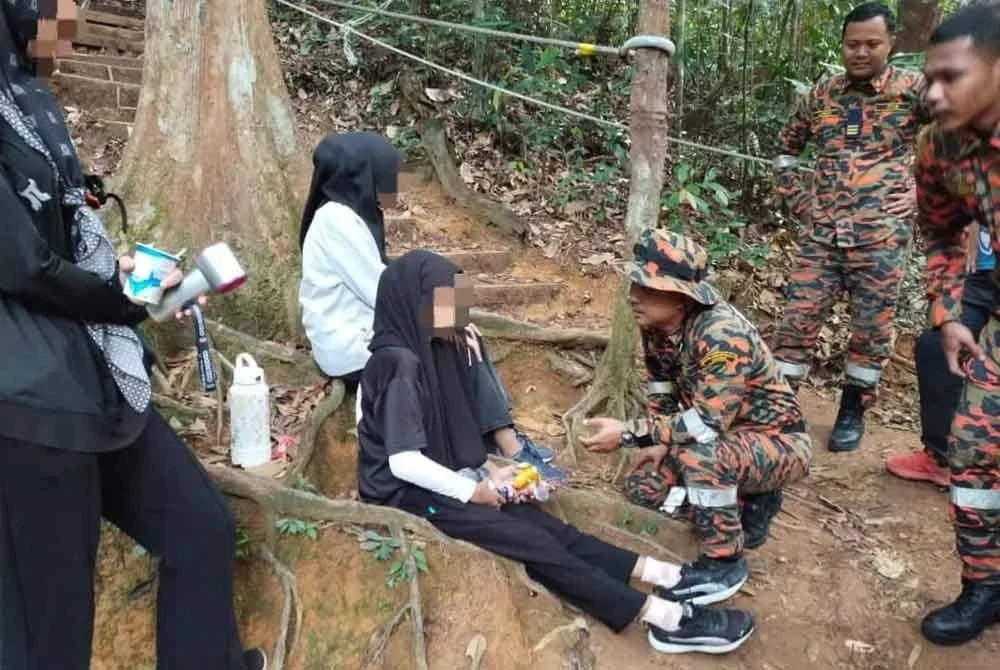 Anggota bomba cuba menenangkan remaja perempuan berkenaan setelah berjaya dibawa turun. Foto BBP Kluang