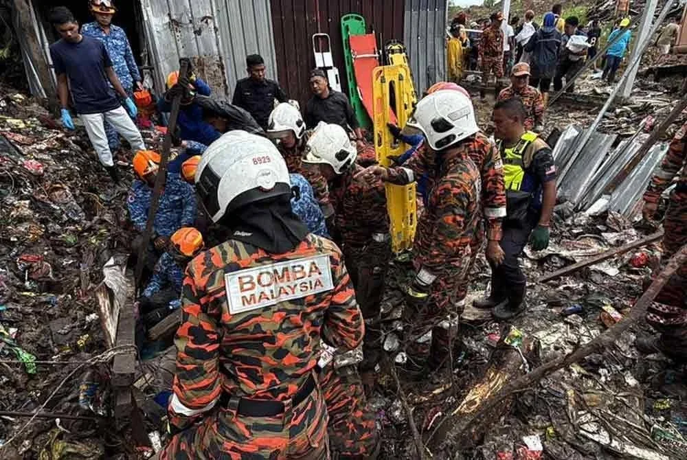 Anggota bomba giat menjalankan operasi mencari mangsa yang tertimbus dalam runtuhan di Kampung Cenderakasih, Kolombong, hari ini. - Foto: Bernama