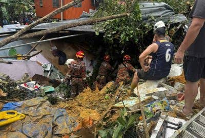 Kejadian tanah runtuh menghempap tiga rumah dan menyebabkan dua tertimbus dalam kejadian di Kampung Mook, Papar. Foto ihsan JBPM Sabah