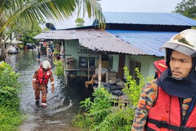 Anggota bomba memantau keadaan banjir kilat di Kampung Baru, Simpang Ampat.
