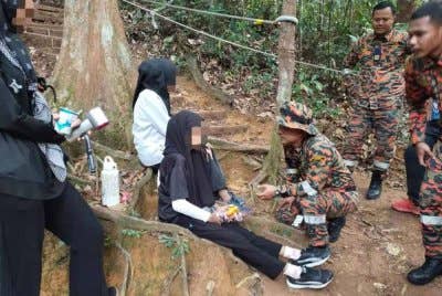Anggota bomba cuba menenangkan remaja perempuan berkenaan setelah berjaya dibawa turun. Foto BBP Kluang