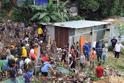 Pasukan bomba dan orang ramai di lokasi kejadian tanah runtuh di Kampung Cenderakasih, Kota Kinabalu. - Foto: JBPM Sabah
