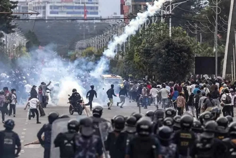 Anggota polis rusuhan melepaskan gas pemedih mata untuk menyuraikan penunjuk perasaan di hadapan bangunan Parlimen, Kathmandu pada 8 September 2025.