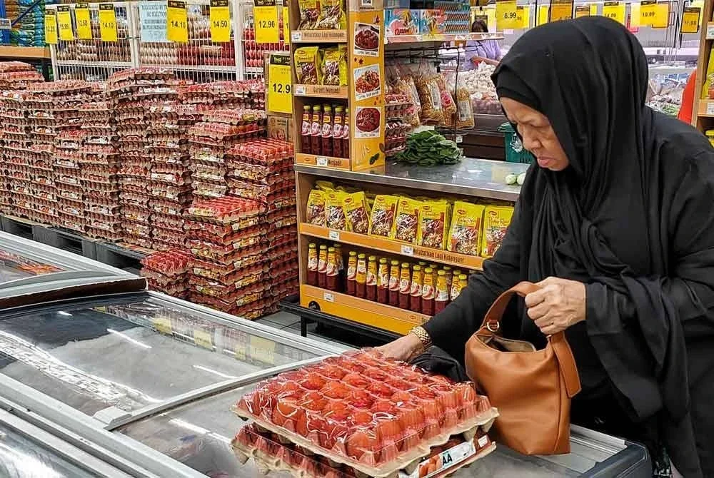 Seorang pelanggan membeli telur di sebuah pasar raya di Kuantan.