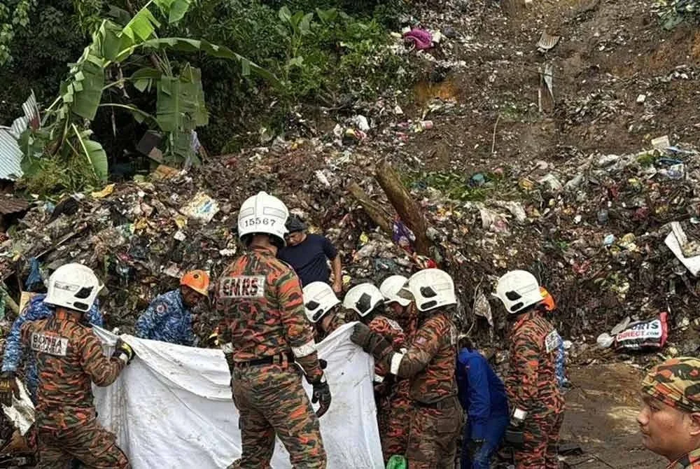 Anggota bomba giat menjalankan operasi mencari mangsa yang tertimbus dalam runtuhan di Kampung Cenderakasih, Kolombong, hari ini. - Foto: Bernama