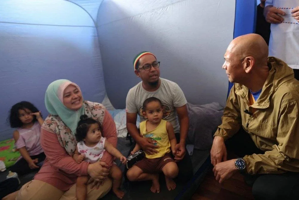 Armizan yang juga Menteri Perdagangan Dalam Negeri dan Kos Sara Hidup menyantuni mangsa-mangsa banjir Kinarut di Pusat Penempatan Sementara (PPS) Dewan Lok Kawi Height Kinarut, Papar hari ini. Foto: Bernama