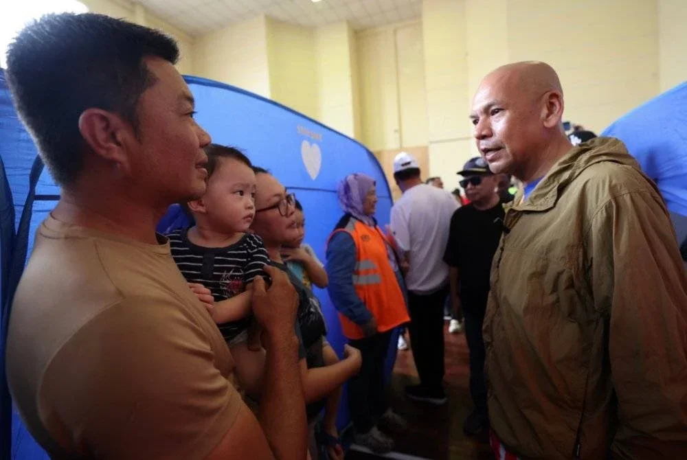 Armizan menyantuni mangsa-mangsa banjir Kinarut di PPS Dewan Lok Kawi Height Kinarut pada Selasa. Foto Bernama