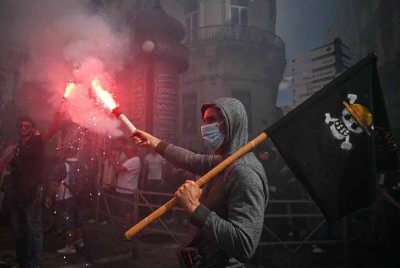 Seorang penunjuk perasaan membawa bendera itu ketika demonstrasi di Montpellier, Perancis. Foto: Agensi