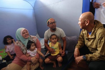 Armizan yang juga Menteri Perdagangan Dalam Negeri dan Kos Sara Hidup menyantuni mangsa-mangsa banjir Kinarut di Pusat Penempatan Sementara (PPS) Dewan Lok Kawi Height Kinarut, Papar hari ini. Foto: Bernama