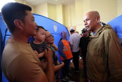 Armizan menyantuni mangsa-mangsa banjir Kinarut di PPS Dewan Lok Kawi Height Kinarut pada Selasa. Foto Bernama