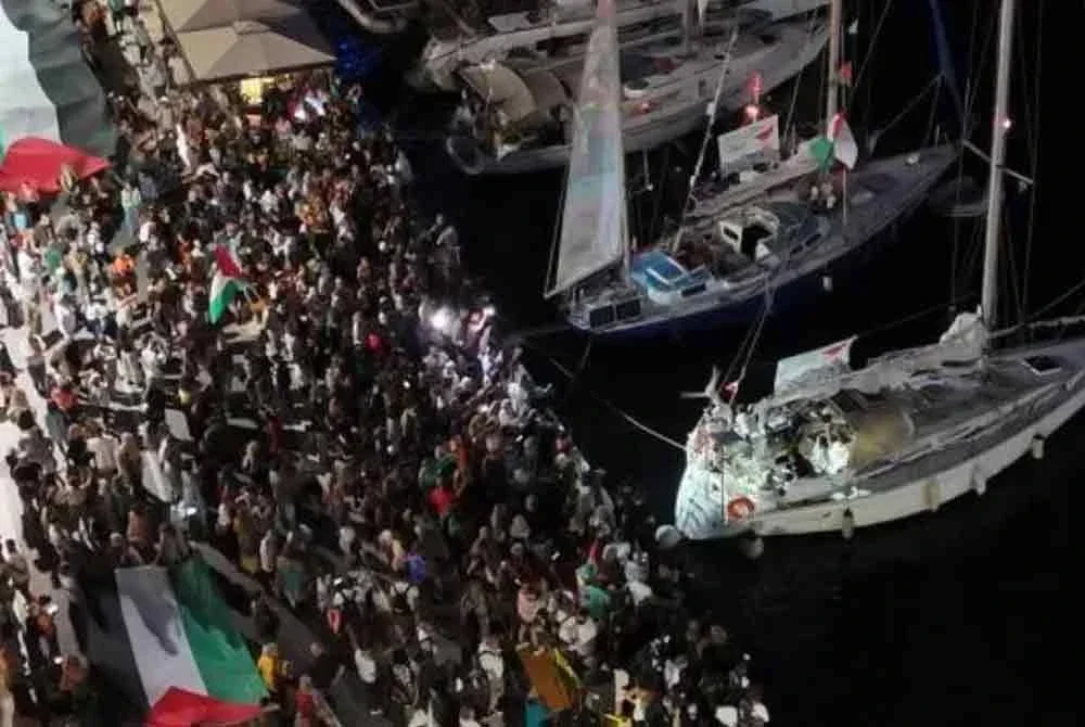 Tangkap layar daripada video dron menunjukkan orang ramai berkumpul di pelabuhan Ermoupolis ketika keberangkatan dua kapal layar, Electra dan Oxygen, yang merupakan sebahagian daripada Global Sumud Flotilla dengan misi menuju Gaza. - Reuters