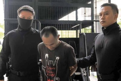 Tertuduh (tengah) dibawa keluar dari Mahkamah Sesyen Kota Bharu pada Rabu.