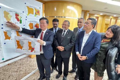 Kon Yeow (kiri) menunjukkan peta sempadan bandar seluruh Pulau Pinang dalam sidang media pada Rabu.