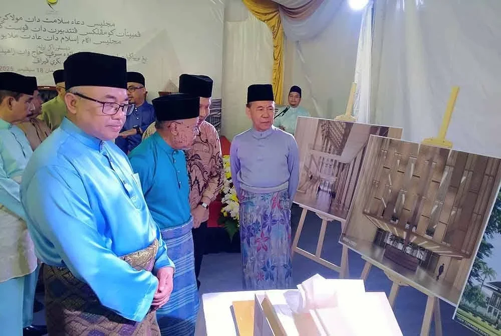 Mohd Annuar (kanan) melihat model bangunan baharu KPPK selepas Majlis Doa Selamat Mula Kerja Pembinaan KPPK MAIPk di sini pada Khamis.