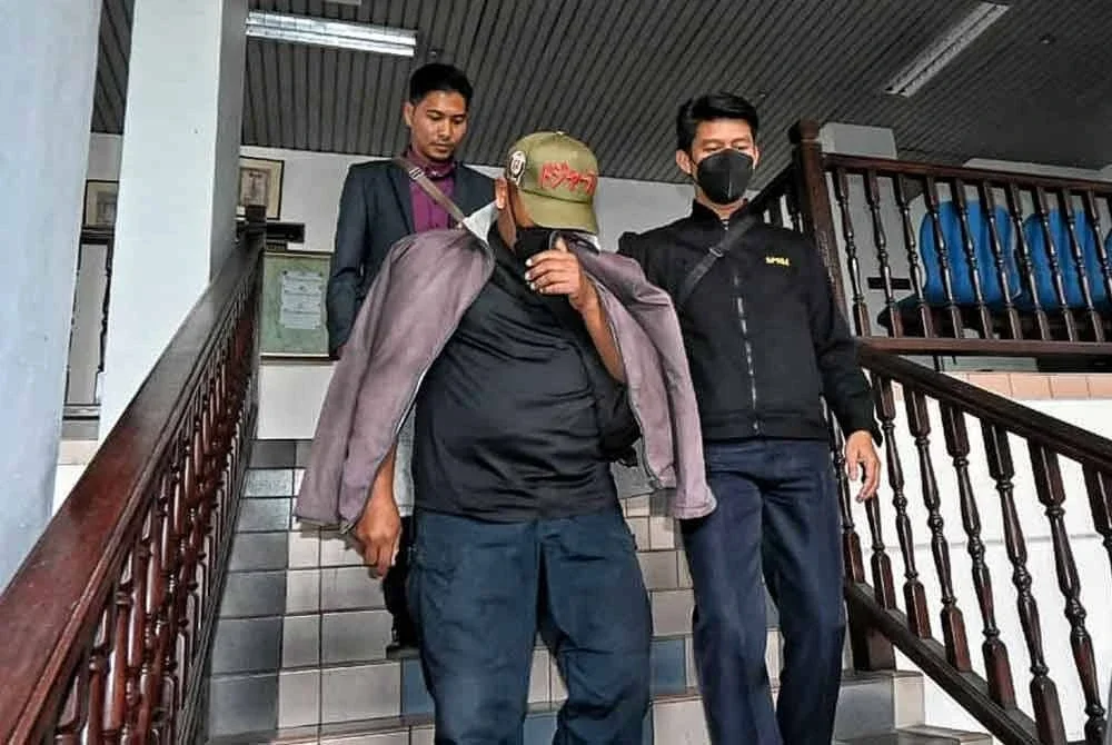 Mohd Rizuan (kiri) ketika dibawa keluar dari Mahkamah Sesyen di sini pada Khamis.