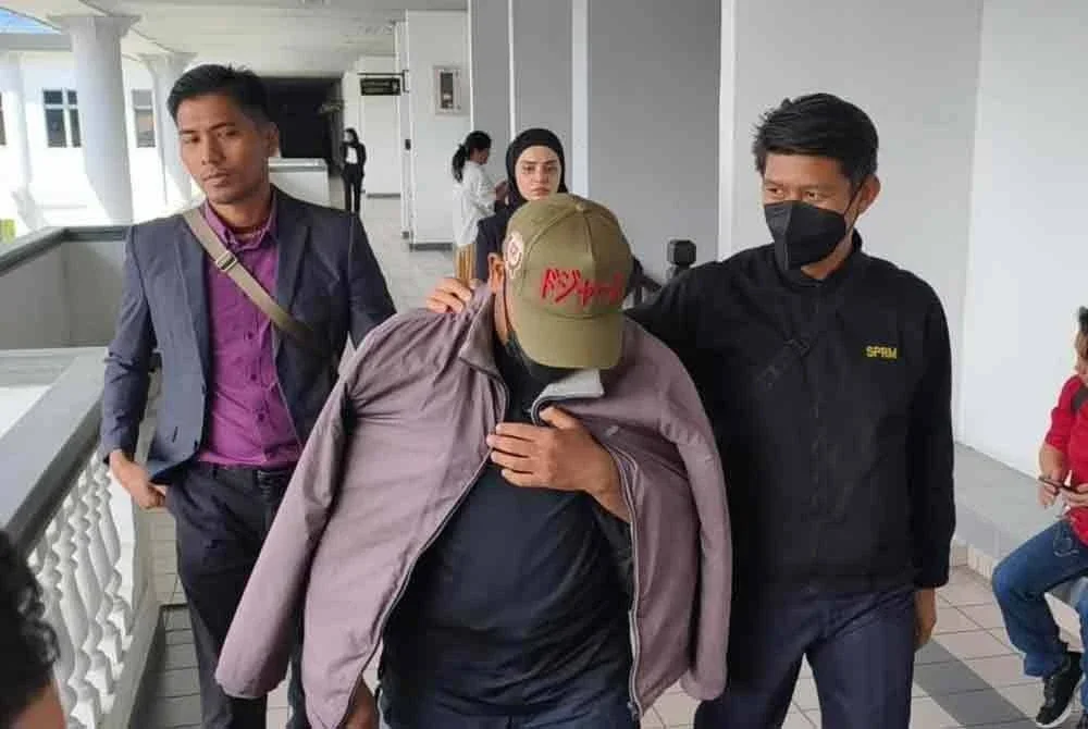 Che Fazdlie Izwan (tengah) didenda RM10,000 selepas mengaku bersalah menerima rasuah di Mahkamah Sesyen Melaka pada Khamis.