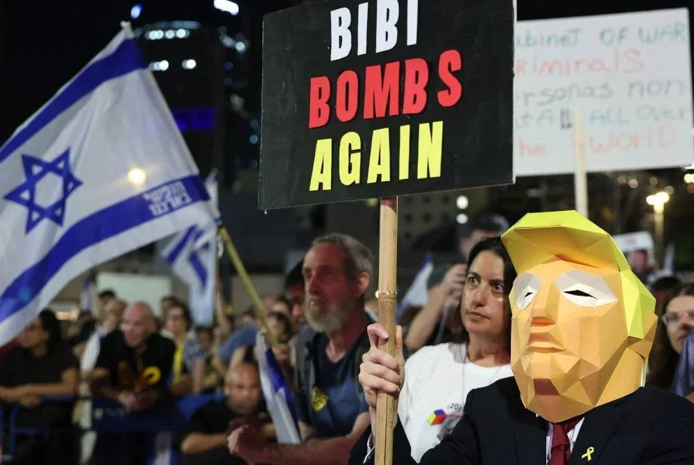 Seorang penunjuk perasaan memakai topeng muka wajar Presiden AS, Donald Trump ketika menyertai protes itu.