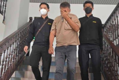 Kau Lik (tengah) ketika dibawa keluar dari Mahkamah Sesyen di sini pada Jumaat.