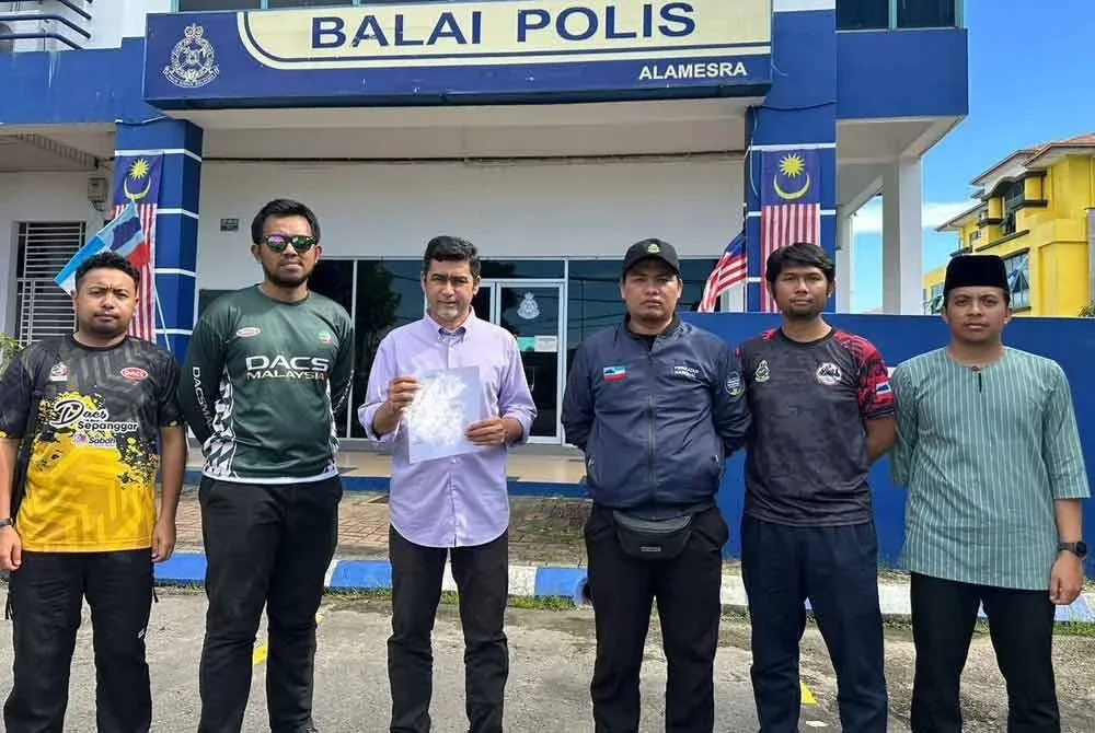 Aliakbar (tiga dari kiri) selepas membuat laporan polis di Balai Polis Alamesra, Kota Kinabalu.
