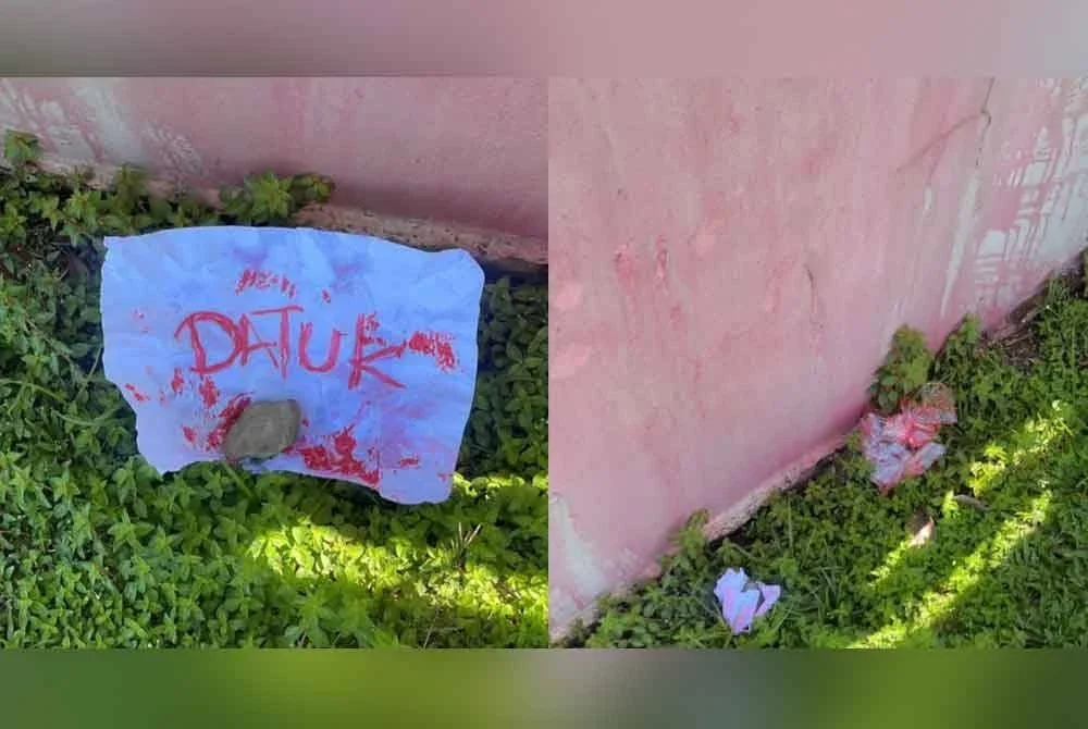 Tulisan 'DATUK' menggunakan cat merah dan batu ditemui di pagar rumah Aliakbar.