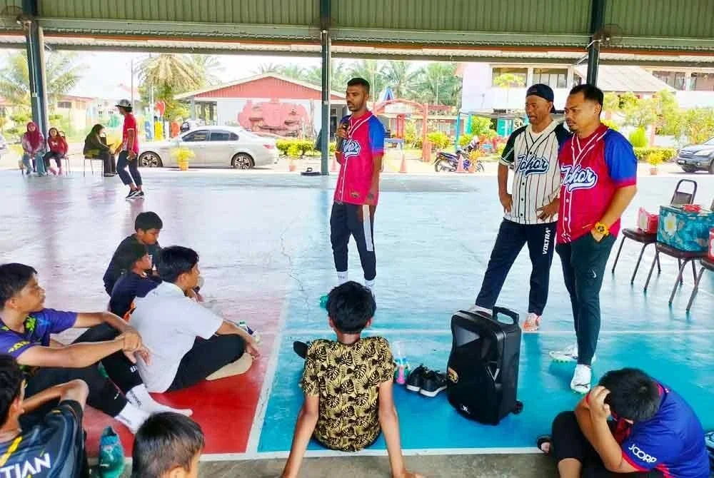 Gopi (kiri) dan Omar (tengah) memberi bimbang kepada bakat cilik bola sepak di SK Sri Benut.