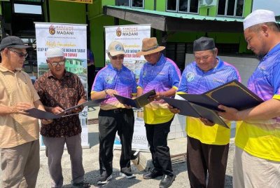 Azlikamil (tiga dari kiri) dan wakil penerima melihat sijil akuan penerimaan selepas Majlis Penyerahan Siap Kerja Projek Naik Taraf dan Baik Pulih Lima Surau KAM di Surau Parit 5 Timur pada Sabtu.