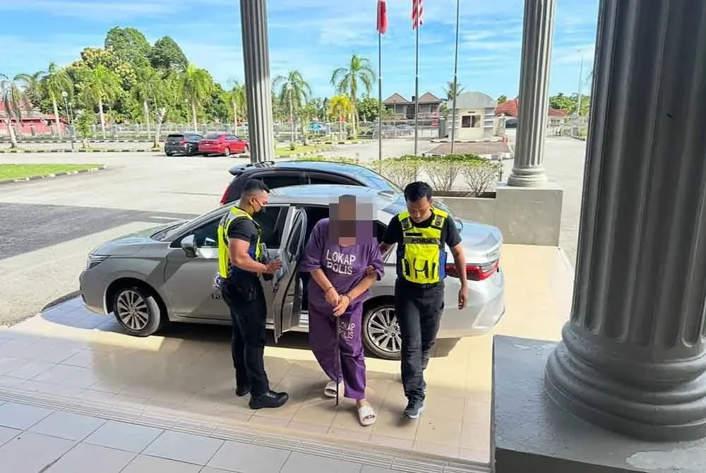 Suspek (tengah) ketika dibawa ke Mahkamah Pasir Mas minggu lepas.