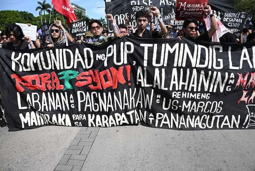 Penunjuk perasaan mengangkat kain rentang menyeru masyarakat bangkit menentang rasuah ketika perhimpunan membantah projek kawalan banjir palsu di Manila pada 21 September 2025.