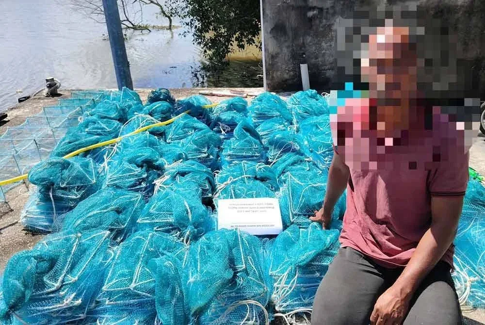 Suspek bersama bubu naga yang dirampas. FOTO MARITIM