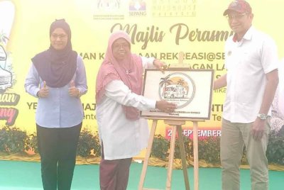 Aiman Athirah (tengah) diiringi Yang Dipertua Majlis Perbandaran Sepang (MPSepang), Dr Ani Ahmad (kiri) menandatangani plak perasmian Taman Rekreasi Kenderaan di Pantai Bagan Lalang di sini pada Ahad.