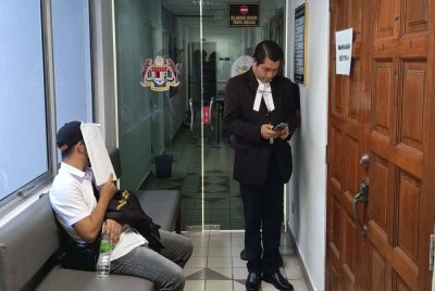 Tertuduh (kiri) ketika dihadapkan di Mahkamah Sesyen Kuala Terengganu atas tiga pertuduhan menerima suapan pada April 2023.