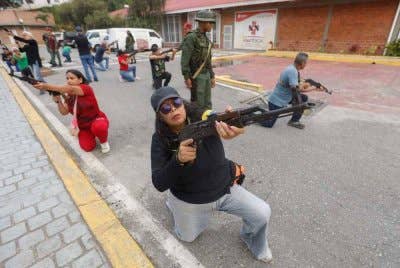 Anggota Majlis Komuniti dan Majlis Sivil memegang senjata semasa latihan ketenteraan di Fort Tiuna, Caracas. Foto AFP