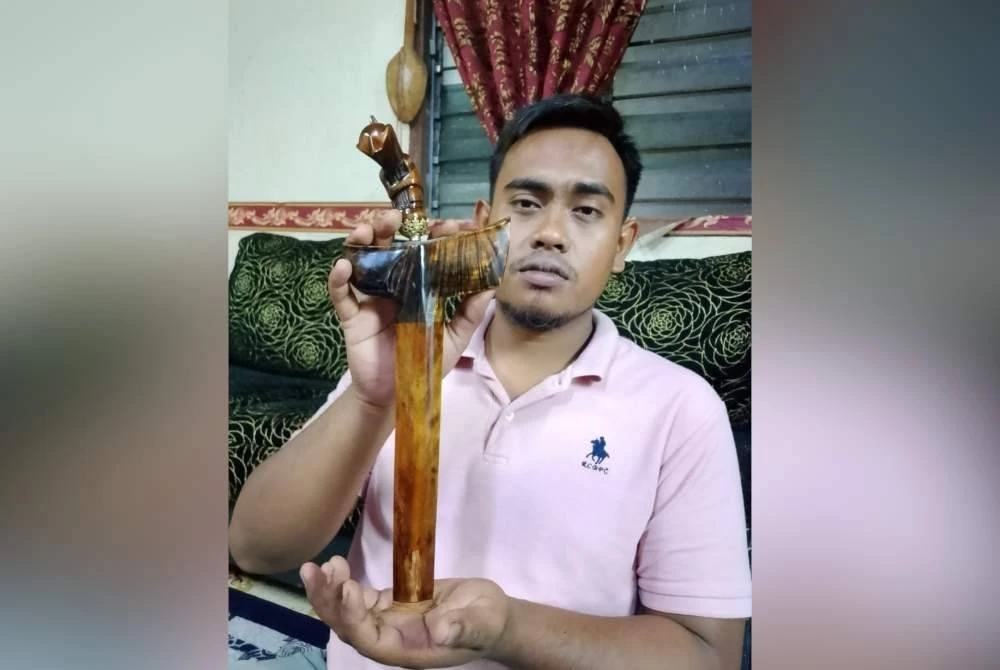 Muhammad Nazrul bersama keris batu kerikil yang telah siap ditempa bersama hulu serta sarungnya.