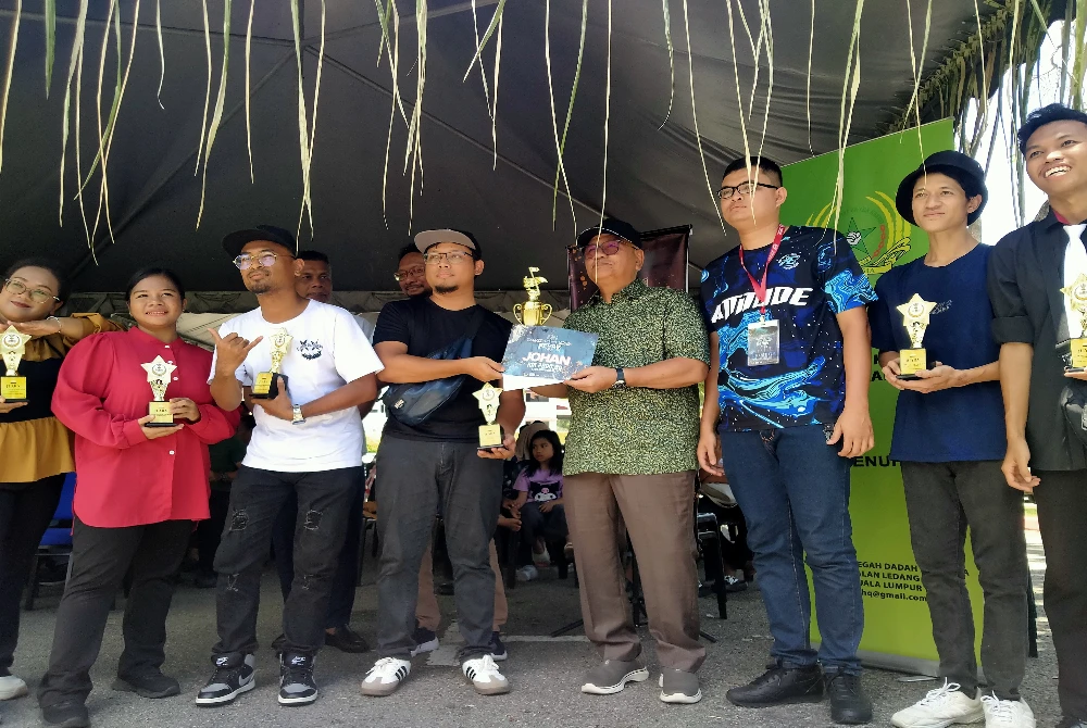 Mohd Zolkafly (empat dari kanan) menyampaikan piala iringan kepada kumpulan Mijo's yang menjadi johan sempena ABOTBA Perak 2025 di pekarangan Stadium Ragbi, Kompleks Sukan Ipoh pada Ahad.