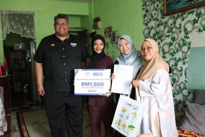 Norliza (dua dari kanan) menyerahkan menyempurnakan simbolik penyerahan WPP berjumlah RM1,500 kepada pelajar ketika sesi ziarah rumah ke rumah.