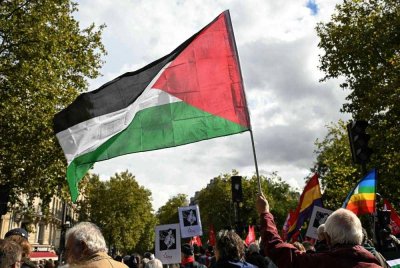 Seorang penunjuk perasaan mengibarkan bendera Palestin semasa menyertai perarakan yang menuntut pengiktirafan negara Palestin dan penghentian pembunuhan beramai-ramai di Paris pada 21 September 2025. Foto AFP