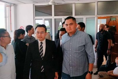 Dr Muhamad Akmal (kanan) bersama peguamnya ketika hadir di Mahkamah Bukit Mertajam, pada Isnin.