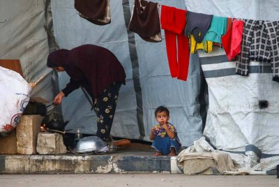 Penduduk Palestin yang dipaksa berpindah dari Bandar Gaza terpaksa mendirikan khemah sementara untuk berlindung di tepi jalan. Foto AFP