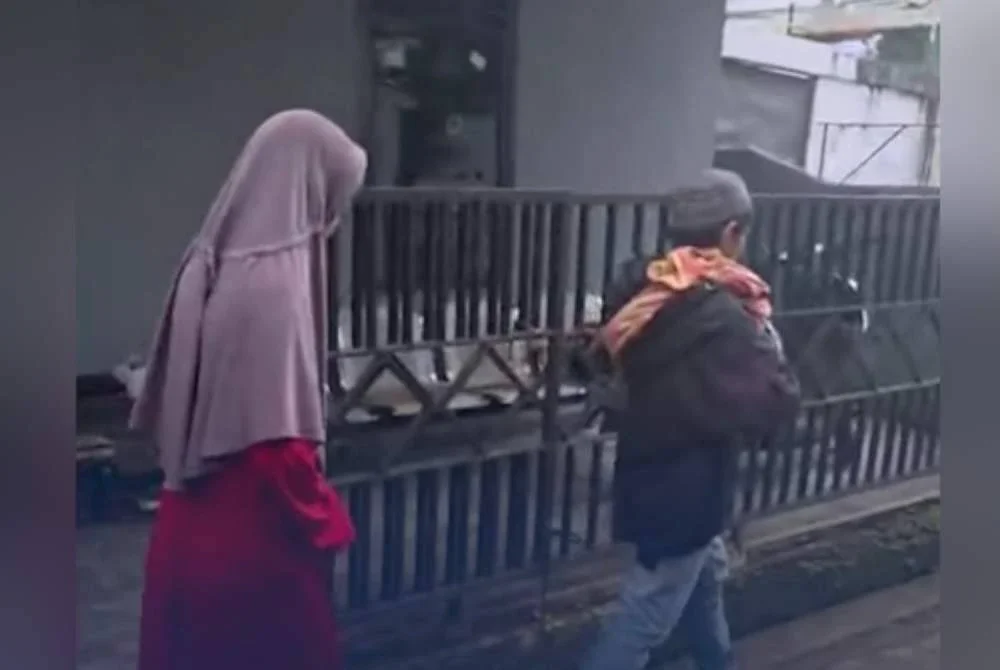 Sepasang suami isteri berjalan sambil mengendong jenazah bayi mereka akibat tiada tempat tinggal dan diusir keluarga. Foto Agensi