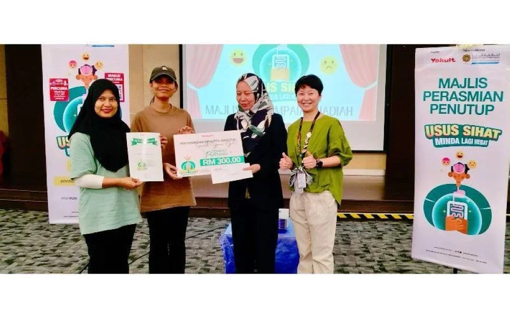 Mazlyn Mena (dua dari kanan) menyampaikan hadiah kepada pemenang tempat pertama Pertandingan Mencipta Smoothie, Smooth Your Gut.