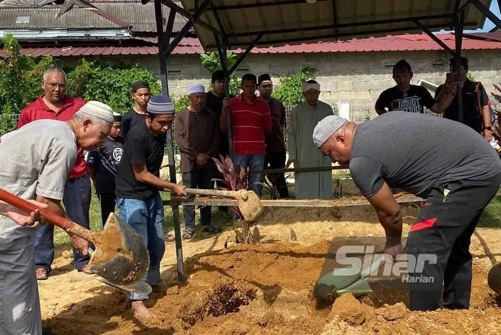 Amir Raja Lawak dibantu ahli keluarga menguruskan pengkebumian arwah bapanya di Tanah Perkuburan Islam Makam Tok Kenali, Kubang Kerian, Kota Bhau pada Selasa.Foto:SINAR HARIAN/HAZELEN LIANA KAMARUDIN