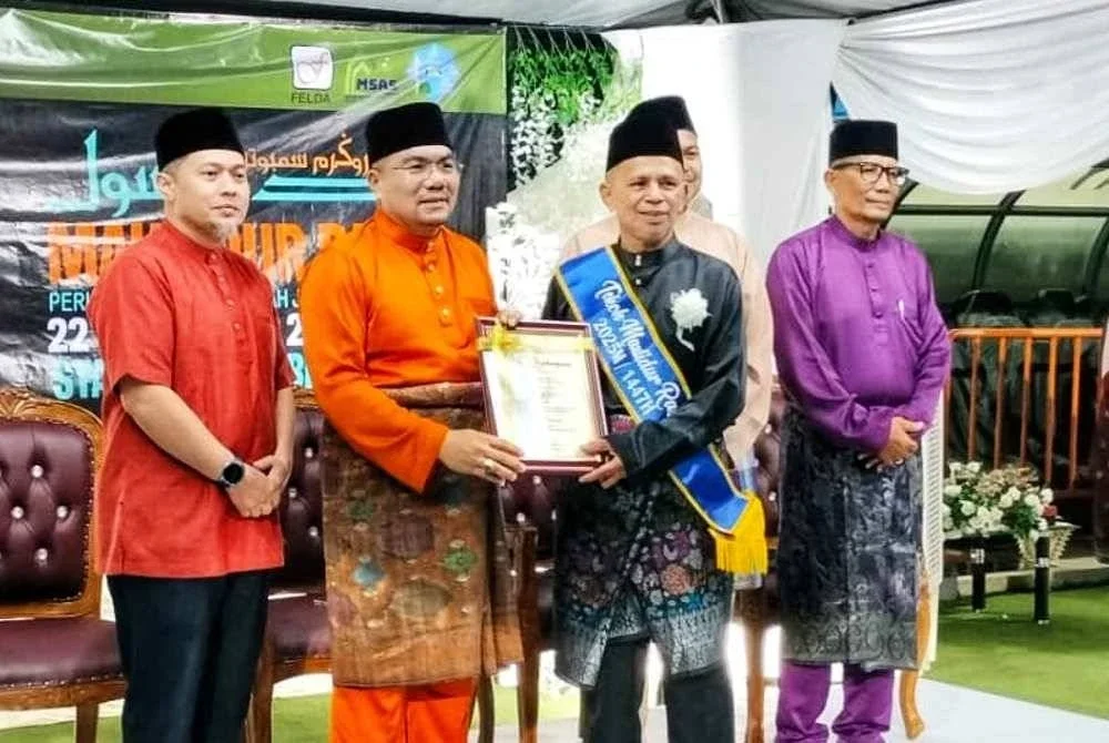 Razak (kanan) menerima anugerah yang disampaikan oleh Amizar.